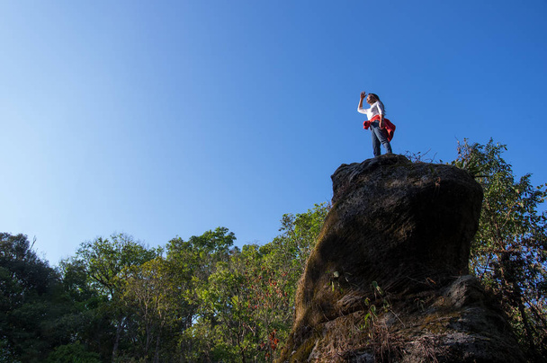 Vrouw staande op Rocky Cliff en kijken naar View - Foto, afbeelding