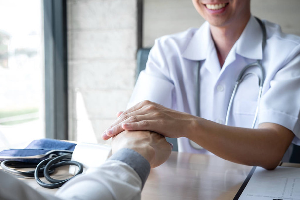 Imagem do médico segurando a mão do paciente para incentivar, falando sagacidade
 - Foto, Imagem