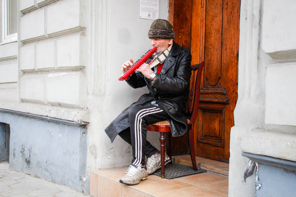 Stary muzyk gra instrument na ulicy Lwow. Ukrain - Zdjęcie, obraz