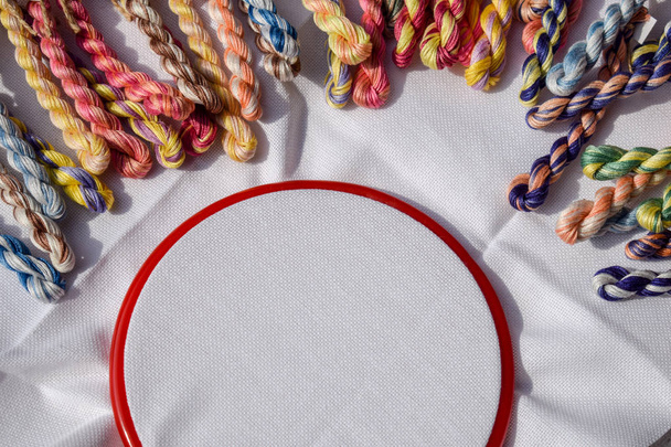 Il cerchio da ricamo con tela e fili da cucito colorati
. - Foto, immagini