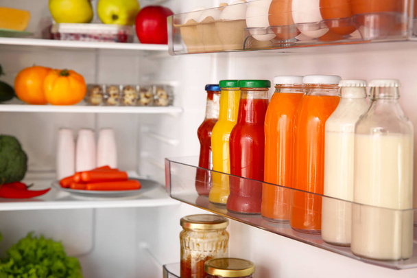 Nyitott hűtőszekrény, tele különböző ételekkel - Fotó, kép