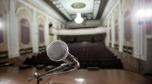 Microphone over the Abstract blurred photo of conference hall or seminar room background - Photo, Image