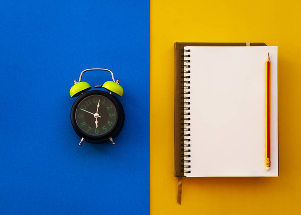 Blank white notepad with pencil and alarm clock isolated on two  - Photo, Image