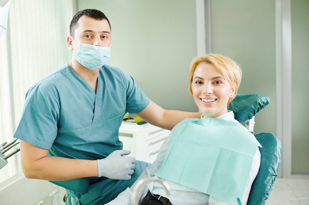 Dentist and patient are smiling - Фото, зображення