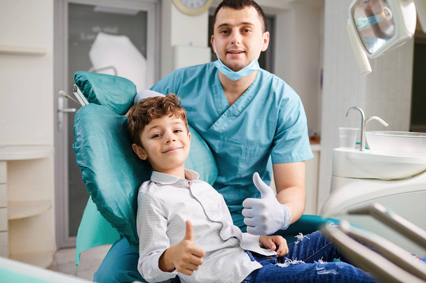 Happy dentist and child raised their thumb - Фото, зображення