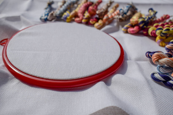 The embroidery hoop with canvas and colored sewing threads. - Photo, Image
