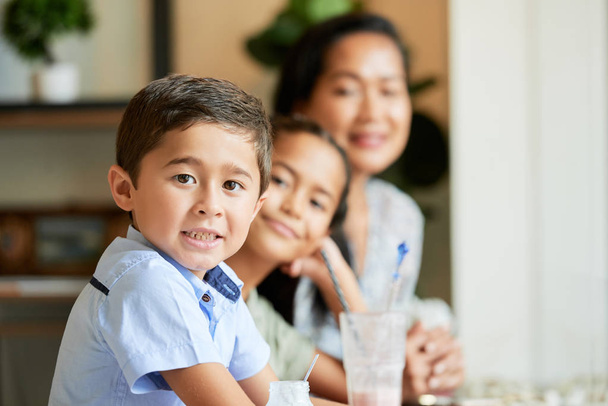 Portrait of little Asian boy and his family in cafe, focus on kid - Photo, Image