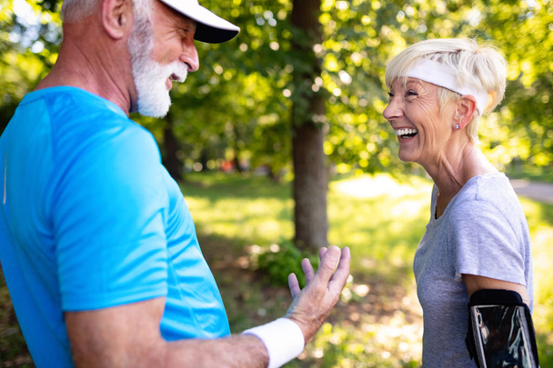 Happy fit senior couple exercising in outdoor park - Photo, image