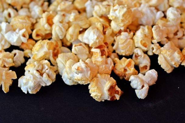 Nahaufnahme von Popcorn auf schwarzem Hintergrund  - Foto, Bild