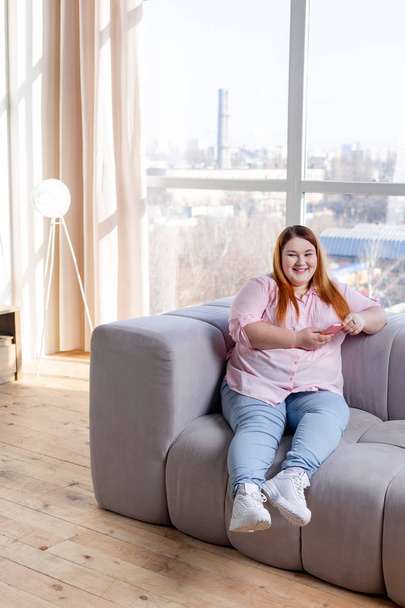 Positive cheerful plump woman resting at home - Foto, Bild