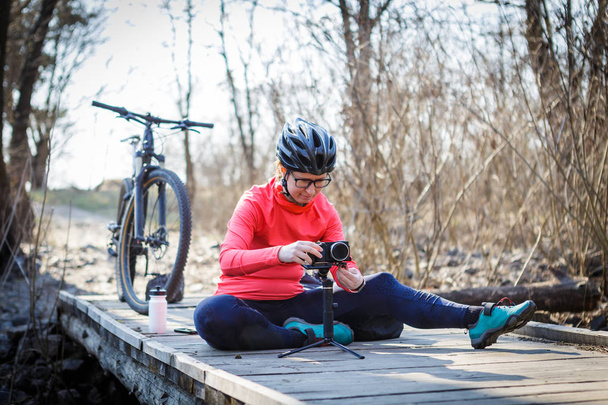 bloguera ciclista mujer sintoniza steadicam al aire libre
 - Foto, imagen