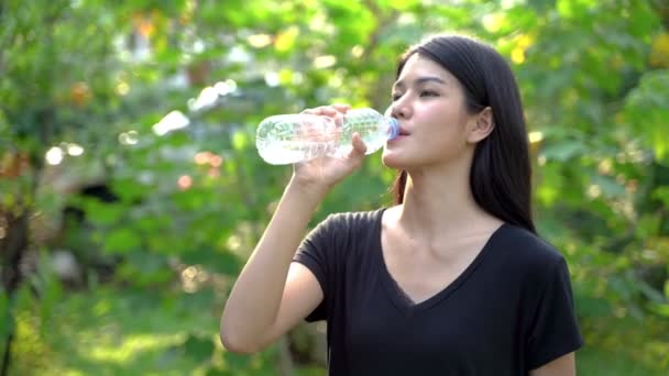 Women drink water from the bottle after exercise. - Footage, Video