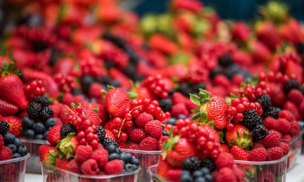 Closeup shot of the mix of different berries on the market counter - Fotoğraf, Görsel