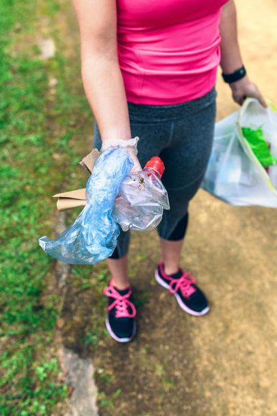 Unerkennbares Mädchen zeigt Müll, den sie gesammelt hat - Foto, Bild