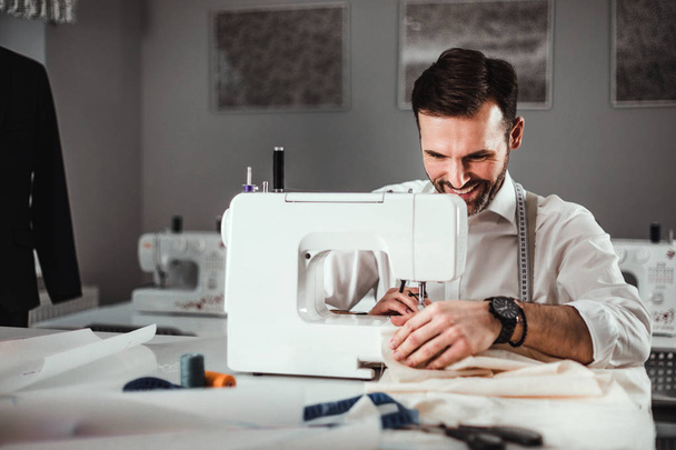 Tailor working with sewing machine at fashion design workshop - Fotoğraf, Görsel