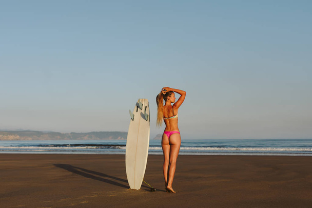 Beautiful surfer at the beach towards the sea - Фото, изображение
