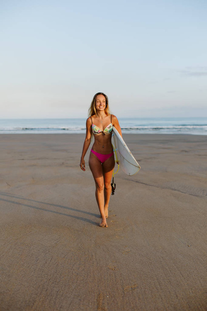 Happy surfer walking at the beach. - Zdjęcie, obraz