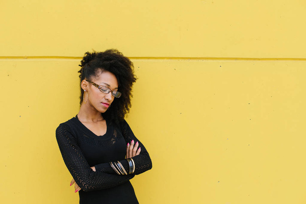 Confident stylish afro hair style professional woman against yellow wall. - Φωτογραφία, εικόνα