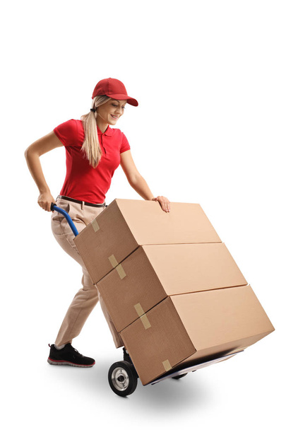 Female worker pushing a hand truck loaded with boxes isolated on white background - Фото, зображення
