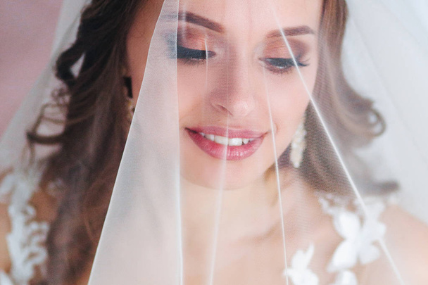 Beautiful bride portrait with veil over her face. Close-up portrait of young gorgeous bride. Wedding. - Valokuva, kuva