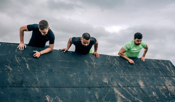 Participantes en muro de escalada de obstáculos - Foto, Imagen