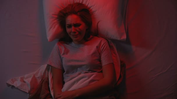 Verletzte junge Frau weint nachts im Bett, häusliche Gewalt, Verzweiflung - Filmmaterial, Video