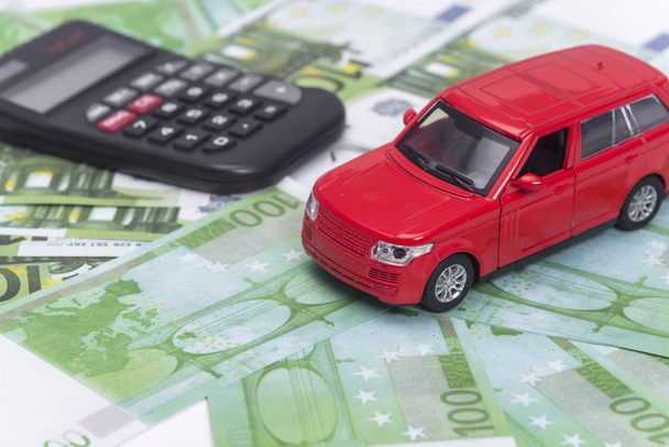 κόκκινο αυτοκίνητο και χρήματα, ευρώ και δολάρια. ασφαλιστική έννοια - Φωτογραφία, εικόνα