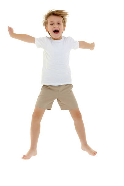 A little boy in a clean white T-shirt is jumping fun. - Foto, Imagem