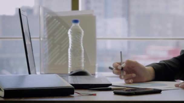 Руки жінка креативний директор сидячи на столі робить нотатки з олівцем на графіку
 - Кадри, відео