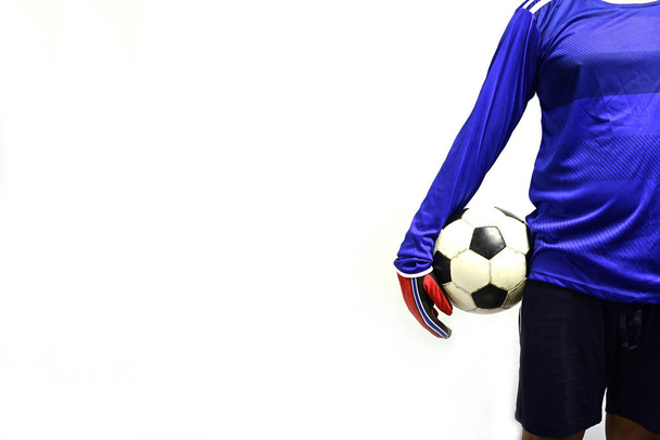 Portiere di calcio in piedi con pallone da calcio per giocare sullo sfondo grigio
 - Foto, immagini