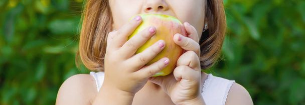 Kind mit einem Apfel. Selektiver Fokus. Natur - Foto, Bild