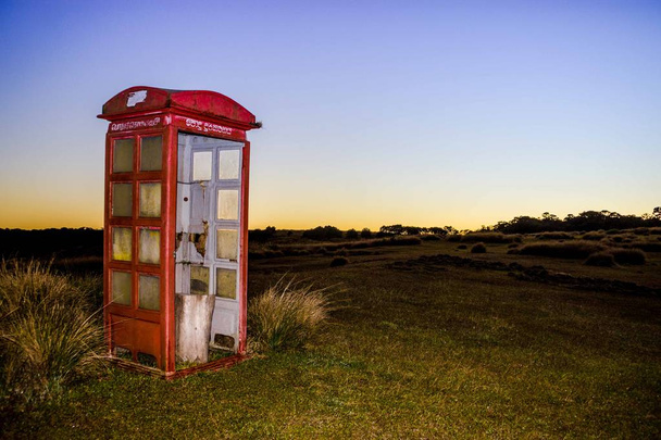 Antigua cabina telefónica en pastizales
 - Foto, Imagen