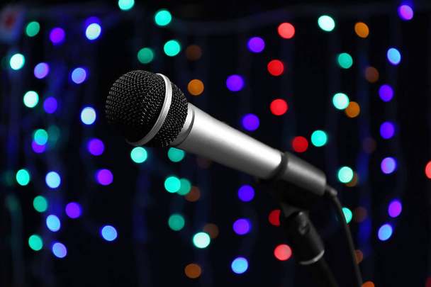 Microphone against dark background with defocused lights - Foto, Imagen