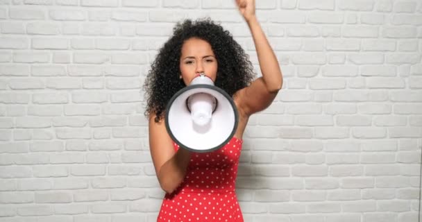 Jóvenes, sentimientos y emociones. Retrato de la furiosa mujer afroamericana gritando con megáfono para protestar. Chica negra mostrando rabia, ira y rebelión por los derechos humanos, huelga, orgullo
 - Metraje, vídeo