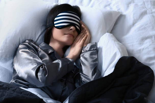 Giovane donna con maschera del sonno a letto di notte
 - Foto, immagini