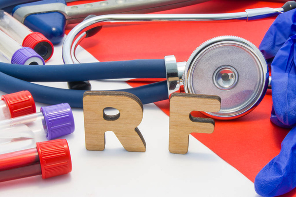 RF lékařská zkratka znamená revmatoidní faktor v krvi v laboratorní diagnostice na červeném pozadí. Chemický název RF je obklopen zkumavkami lékařské laboratoře s krví, stetoskop - Fotografie, Obrázek