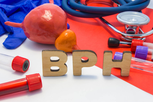 O conceito de BPH de hipertrofia prostática benigna é o aumento da glândula prostática. Abreviatura médica BPH é cercada por modelos de bexiga com próstata, tubos de ensaio de laboratório com sangue, estetoscópio
 - Foto, Imagem