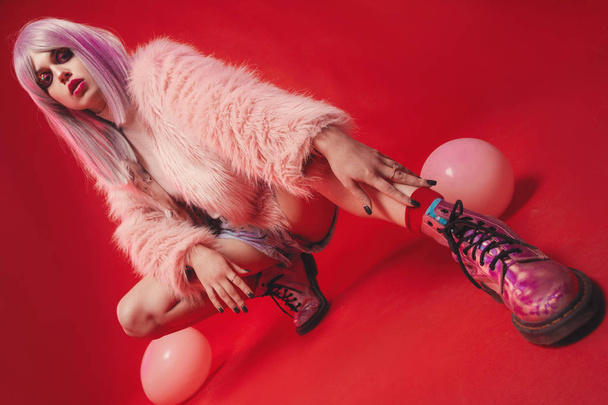 Cheeky girl on pink background in body, fur coat, boots. Pretty  - 写真・画像