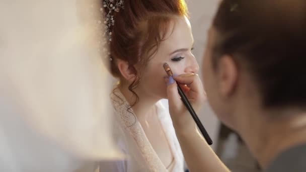 Γάμος μακιγιάζ καλλιτέχνης κάνοντας ένα make up για τη νύφη στο πέπλο. Όμορφο σέξι μοντέλο - Πλάνα, βίντεο