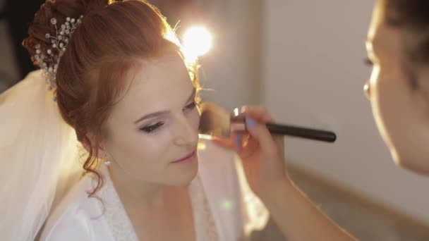 Artista de maquillaje de boda haciendo un maquillaje para la novia en el velo. Hermosa modelo sexy
 - Imágenes, Vídeo