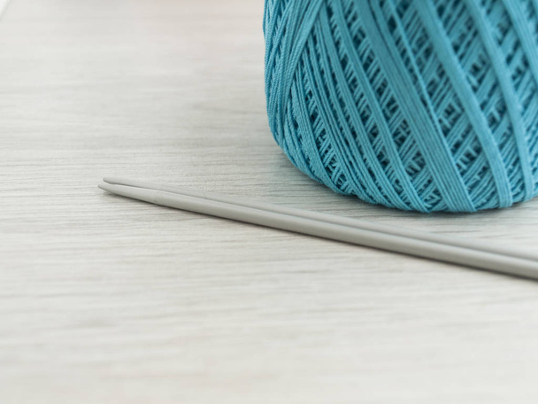 木製の灰色のテーブルのロールと編み針でウールの糸。クローズ アップ - 写真・画像
