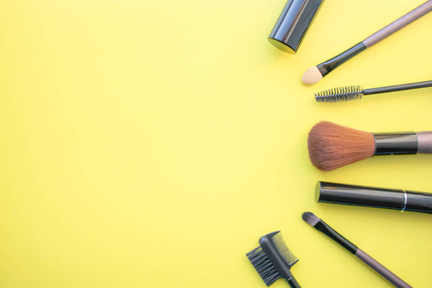 Makeup brushes, brushes for everyday makeup. Cosmetic items on yellow background, closeup. - Photo, Image