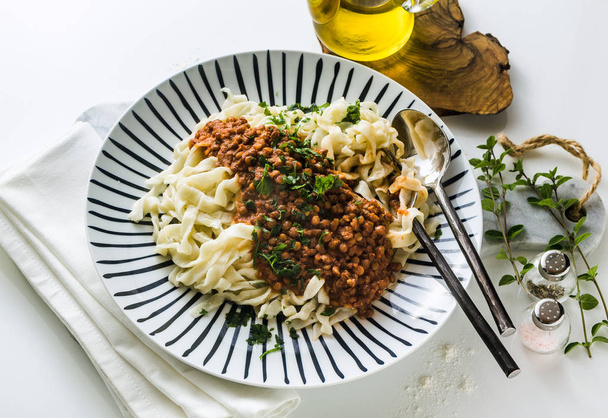 vegan pasta with lentil and tomato sauce in a plate on the table - Фото, зображення