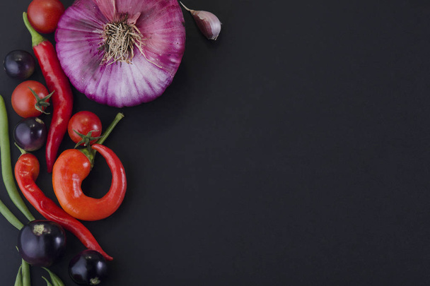siyah arka planda soğan, sıcak biber ve sebze - Fotoğraf, Görsel