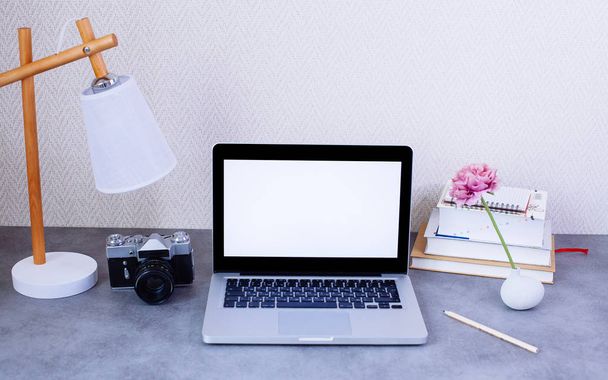 Front view of desktop with blank laptop and decorative items - Foto, afbeelding