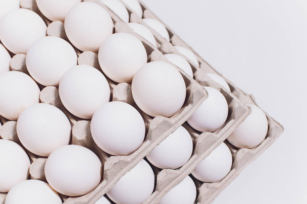 White eggs of a hen in harmless, cardboard packing on a white background. 3 packs. - Фото, зображення