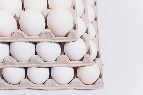 White eggs of a hen in harmless, cardboard packing on a white background. 3 packs. - Foto, Imagen