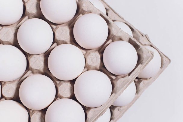 White eggs of a hen in harmless, cardboard packing on a white background. 2 packs. - Foto, Imagem