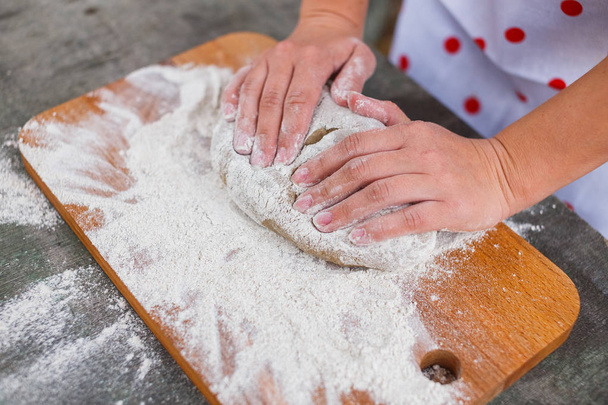 Women's hands knead the dough of dark rye flour - Photo, Image