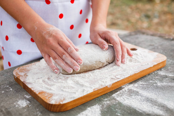 The girl in the woods preparing the dough for the cake - Foto, imagen